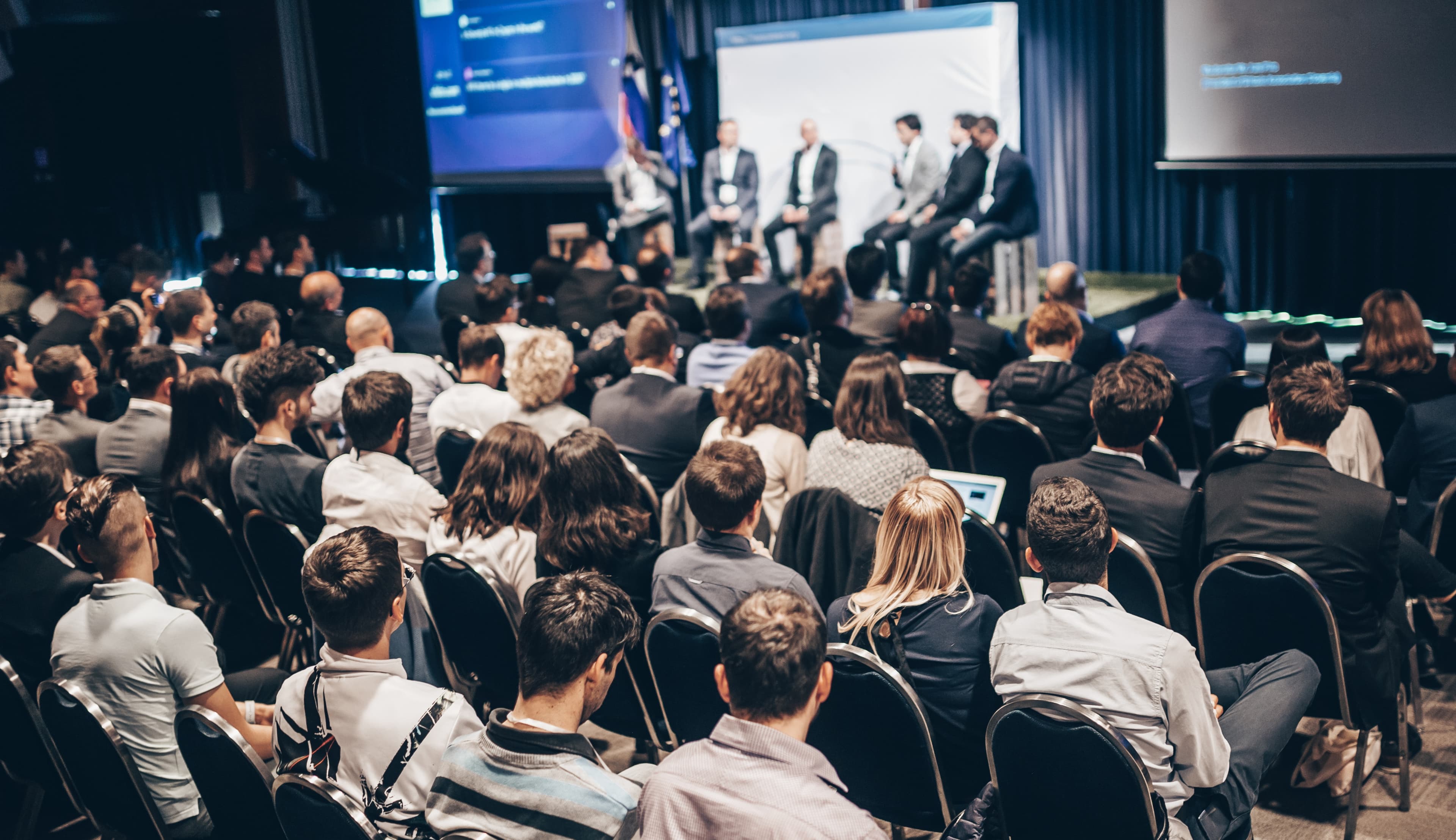 large audience watching a panel AdobeStock 2099577975