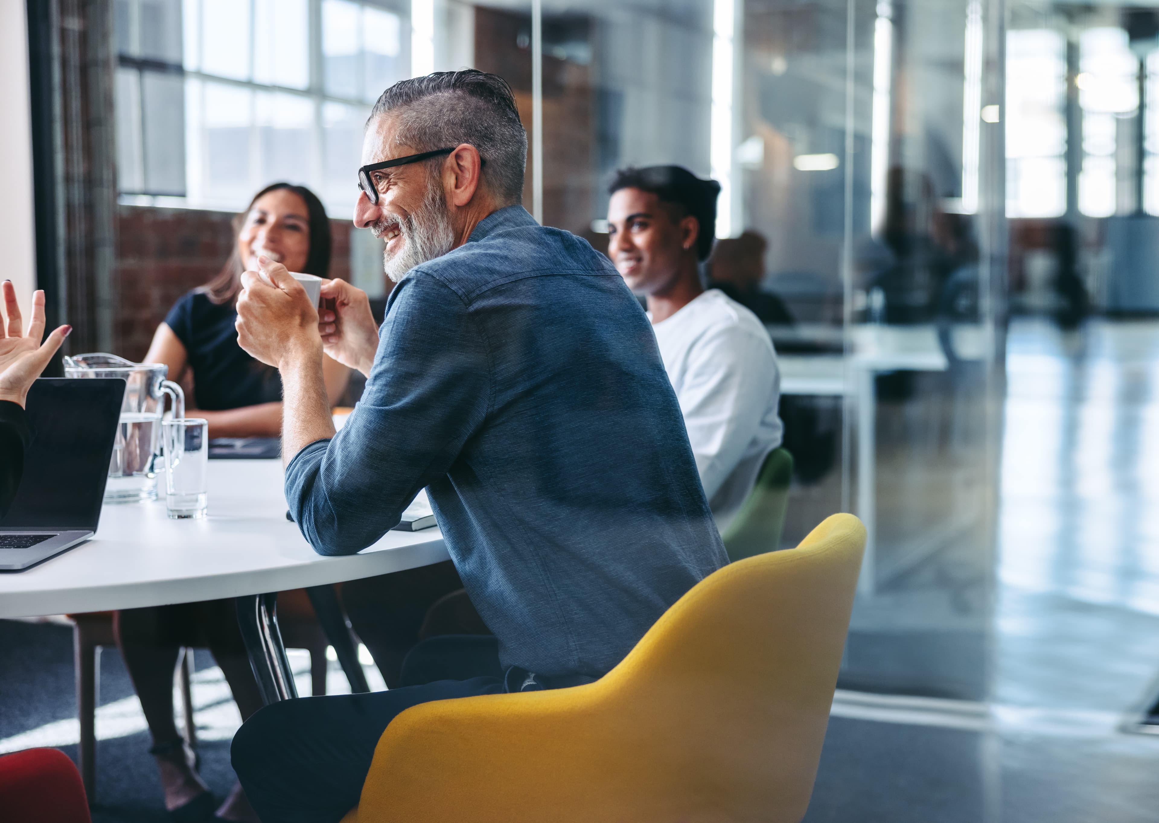 colleagues laughing during a meeting AdobeStock 480143394
