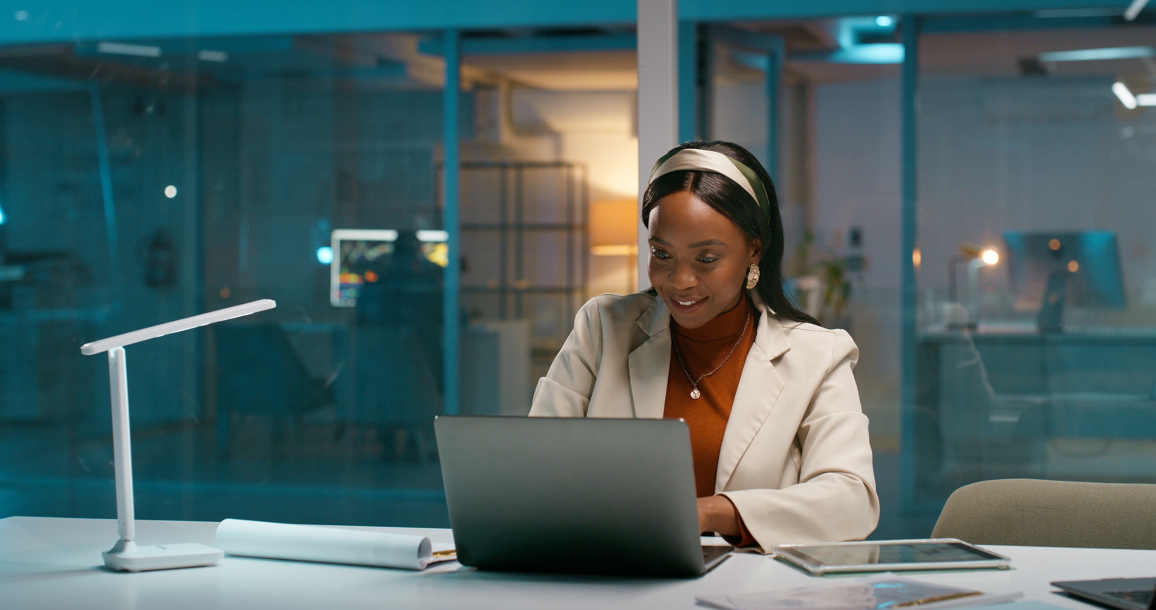 woman sat at desk looking at laptop IS-2229742554