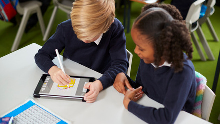 Elevated view of a girl and a boy using a tablet computer iStock-1092191870.jpg