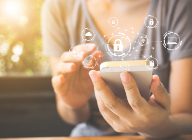 Using smartphone with icon graphic cyber security network of connected devices and personal data iStock-1090870004.jpg